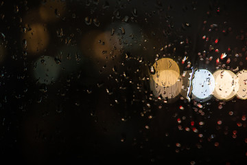 glare on wet glass at night. raindrops on the window. city lights at night.