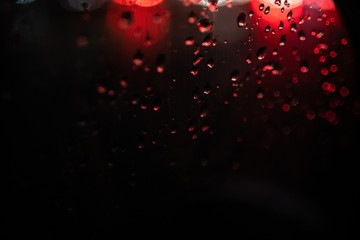 glare on wet glass at night. raindrops on the window. city lights at night.