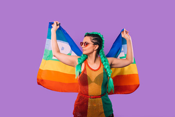 Rainbow flag in the hands of a hipster woman in rasta dress. World peace. On a purple background