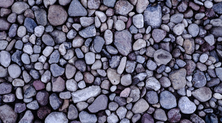 Texture of small sea stones on the wall. Natural rock pebble background shot.