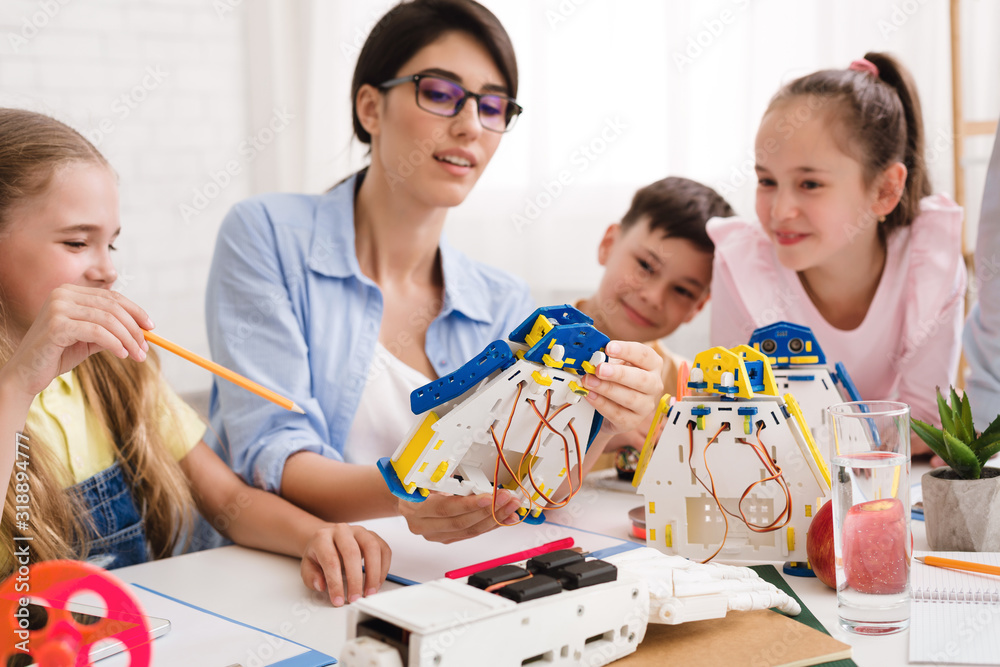 Poster Pupils and teacher constructing robots together in class
