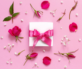 White gift box and flowers on a light pink background