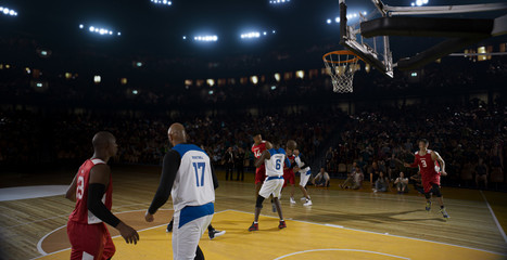 Basketball players on big professional arena during the game. Tense moment of the game.