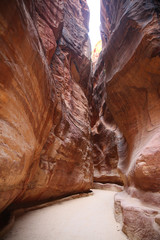 Path through the Siq, which is the narrow gorge passage that you walk along to reach Petra, Jordan.