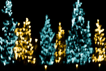 Abstract blurry golden and blue lights in the shape of hearts. Defocused street festive illumination. Valentines day, wedding, love background