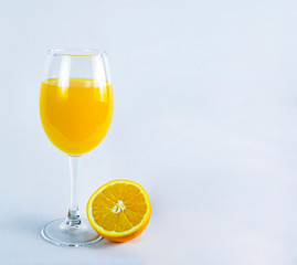 glass of orange juice, orange and orange leaves, on bright background