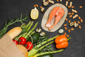 Obraz na płótnie Canvas Concept of healthy eating and longevity. Food sources of omega 3, protein. Paper bag with salmon leavy vegetables, beans nut
