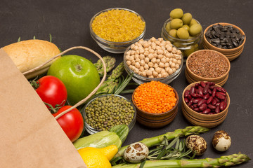 Healthy food for diet and lifestyle. Paper bag with vegetables, beans nuts, quinoa bulgur, chickpeas, flax