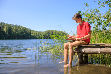 Fototapeta na wymiar Teen boy sketching summer landscape with pastel sticks