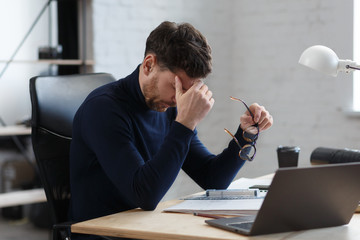 Tired architect working overtime in office. Stressed businessman have financial problems and...
