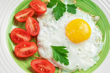Breakfast on plate, fried eggs with tomato. Close up, top view