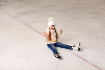 Cute little girl after falling on skating rink
