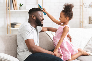 Little girl brushing her young dad's hair