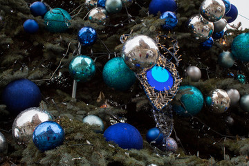 Closeup Christmas tree decorations - balls of blue and silver color and the Market Square in Krakow reflected in them.