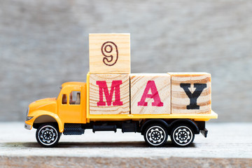 Truck hold letter block in word 9may on wood background (Concept for date 9 month May)