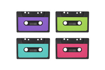 Four magnetic tape cassettes of the 80 s, 90 s. Retro cassettes isolated on white background. Magnetic tape cassette for audio painted in pink and green color, copy space. Retro music concept