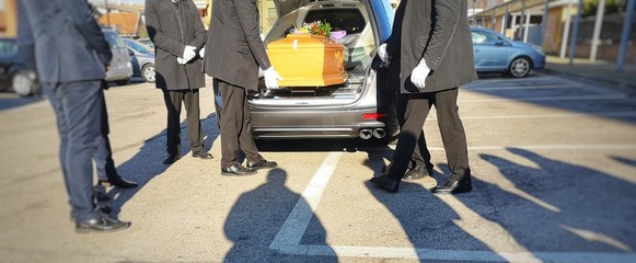 Gravediggers put coffin into car - obrazy, fototapety, plakaty