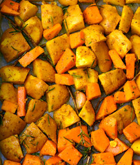 Pumpkin and potatoes cut with various spices, ready to be baked