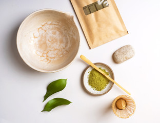 White ceramic spoon with tea of a Matcha on a light gray background