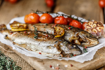 Cooked river trout with spices and ingredient for cooking on rustic background