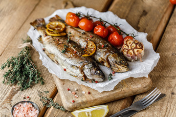 Cooked river trout with spices and ingredient for cooking on rustic background
