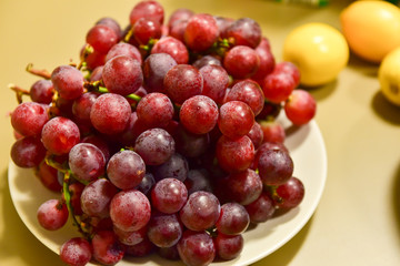 Ripe grape berries in a white plate