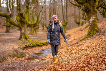 Obraz premium Very happy blonde girl in a beautiful forest walking