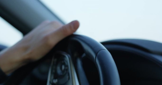 Man turning steering wheel in car - extreme close up on hands