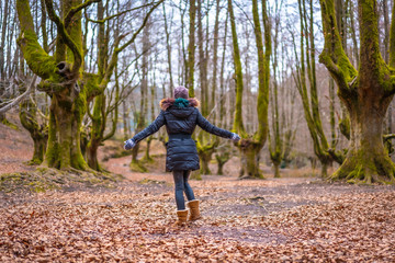 Obraz premium Lifestyle, a young woman in a beautiful forest in autumn from behind