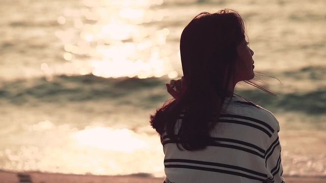 Woman looking at ocean view at sunset thinking about life Girl relaxing in nature enjoying afternoon peace and calm landscape nature background enjoying vacation travel