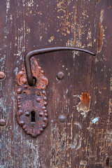 An old wooden door with a wrought iron handle and a lock. Adding Grain.