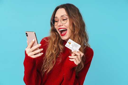 Image of laughing caucasian woman holding cellphone and credit card