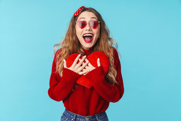 Image of excited blonde woman in sunglasses holding toy heart