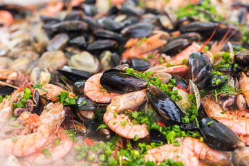 Street food and meal - Spanish paella close-up with shrimp and clams