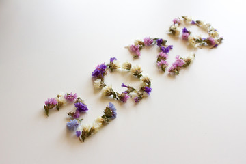 the figure 2020 is laid out of flowers on a white background. image for a postcard. new year. twenty. the view from the top. space for text.