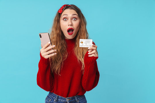 Image of surprised blonde woman holding cellphone and credit card