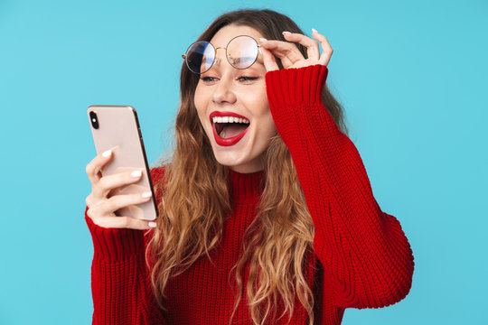 Image of joyful nice woman in eyeglasses using cellphone and smiling