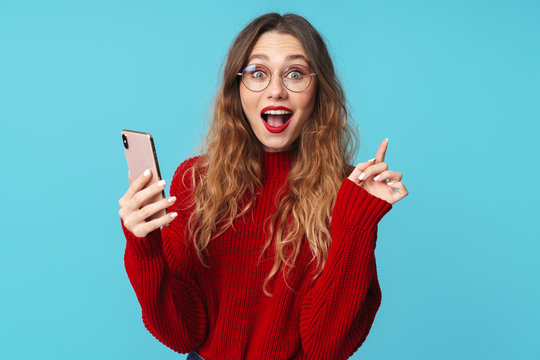 Image of delighted woman using cellphone and pointing finger upward