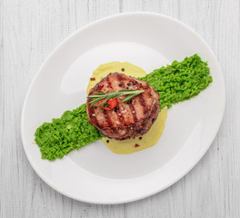 steak mignon with pea puree and cream sauce