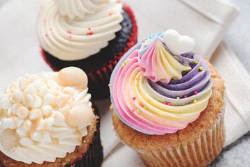 Rainbow cupcake on wood table background.