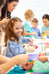 kindergarten children group doing arts and crafts in daycare centre - 318917733