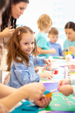 kindergarten children group doing arts and crafts in daycare centre