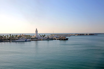 The Port of Malaga, with some small ships docked and the lighthouse on the pier, Andalusia, Southern Spain.