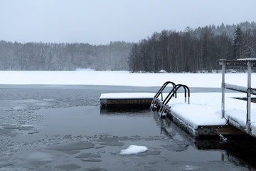Ice swimming or winter swimming spot on a frozen lake in Finland