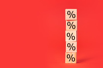 percent sign wood bricks tower. construction from wooden cubes. on a red background