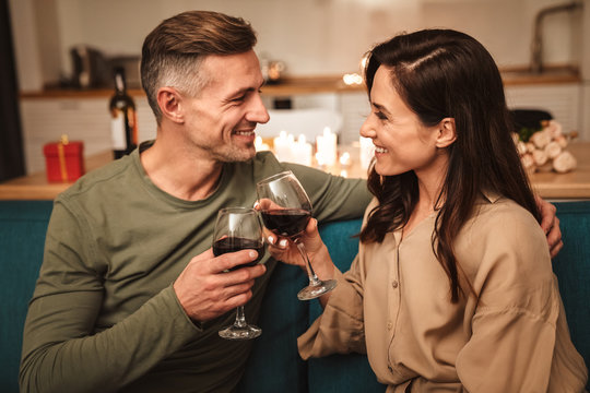 Image of couple drinking red wine while having romantic dinner at home