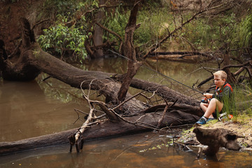 Fototapeta premium Young boy fresh water fishing in isolated river in New South Wales, Australia 
