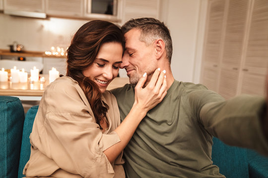 Image Of Couple Taking Selfie While Having Candlelight Dinner At Home