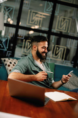 Fototapeta premium Businessman on coffee break using phone. Attractive man in office. 