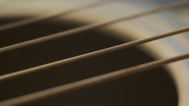 guitar strings vibrate after being touched, close-up